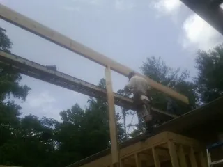Carpenter setting a ridge beam over a new addition frame — Ice Dam Removal by Roofing Brothers in Flag Pond