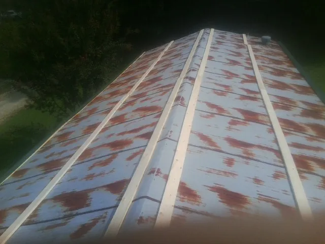 Rusted metal roof panels with new wood purlins before replacement — Storm Damage Roof Repair in Flag Pond by Roofing Brothers