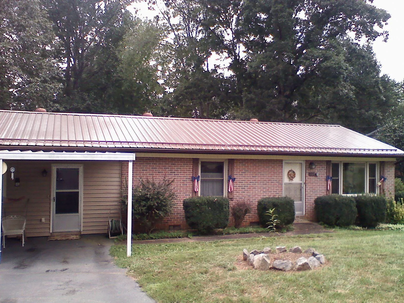 Bronze metal roof and carport on a brick ranch home — Roof Repair work by our crew in Flag Pond